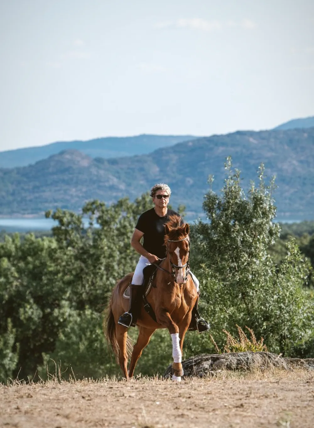 Javier Ávila a caballo, con la Sierra de Guadarrama al fondo