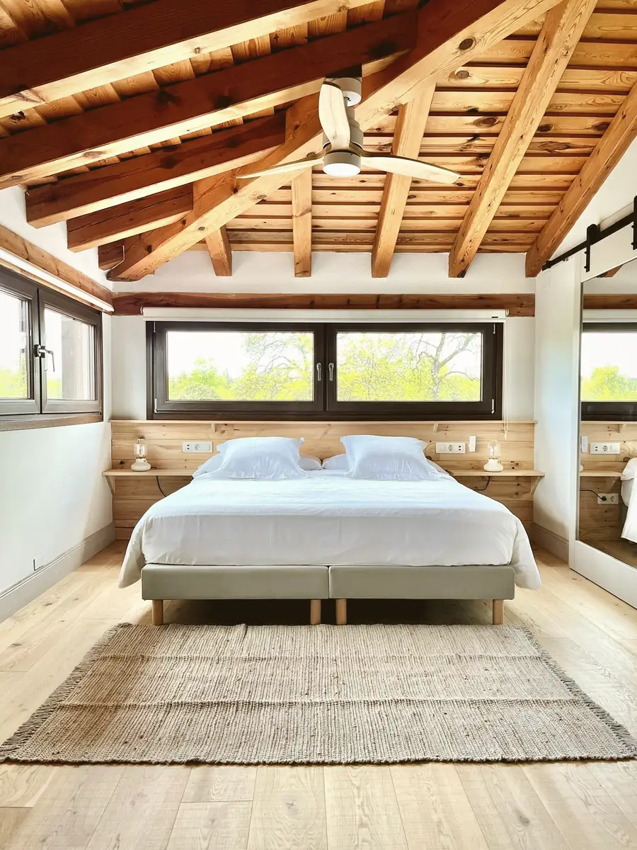 Habitación con vigas de madera y vistas al campo