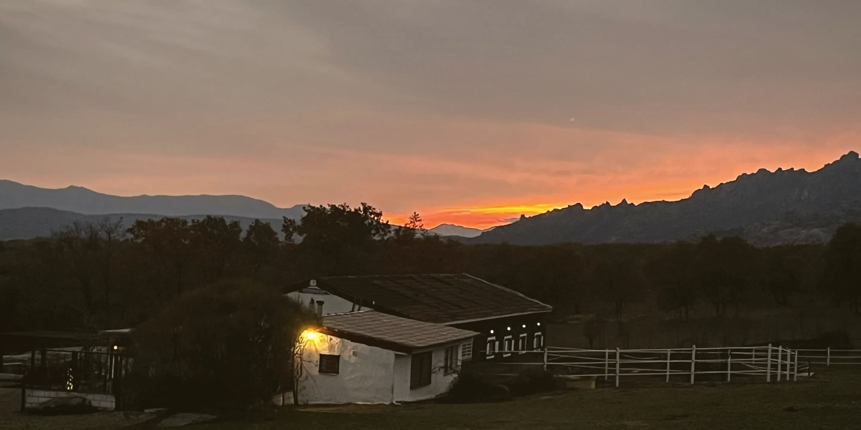Atardecer sobre la finca, con La Pedriza recortada al fondo